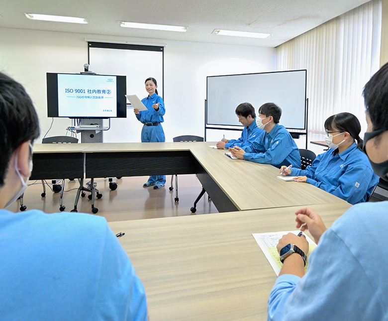 作業服を着た社員が和やかに昼食をとる様子